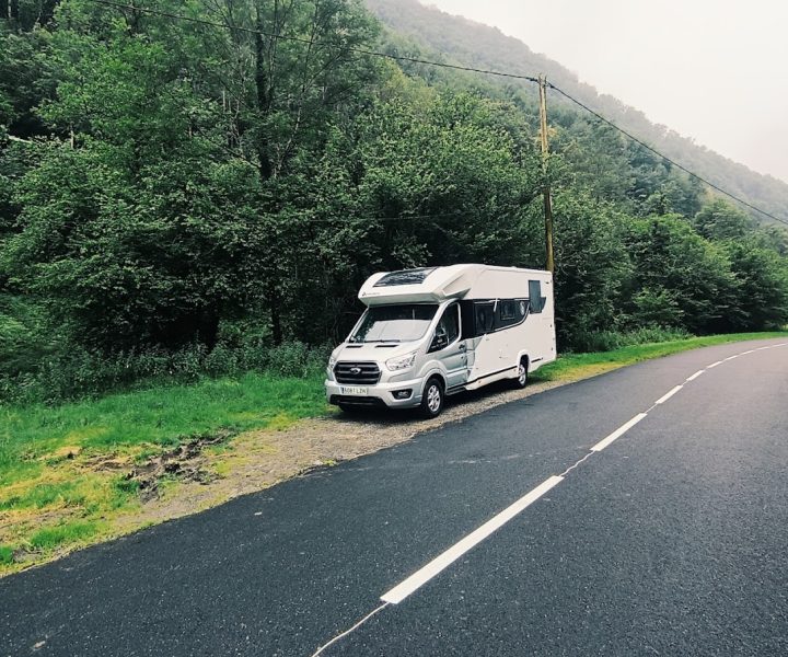 autocaravana aparcada en una carretera con vegetacion