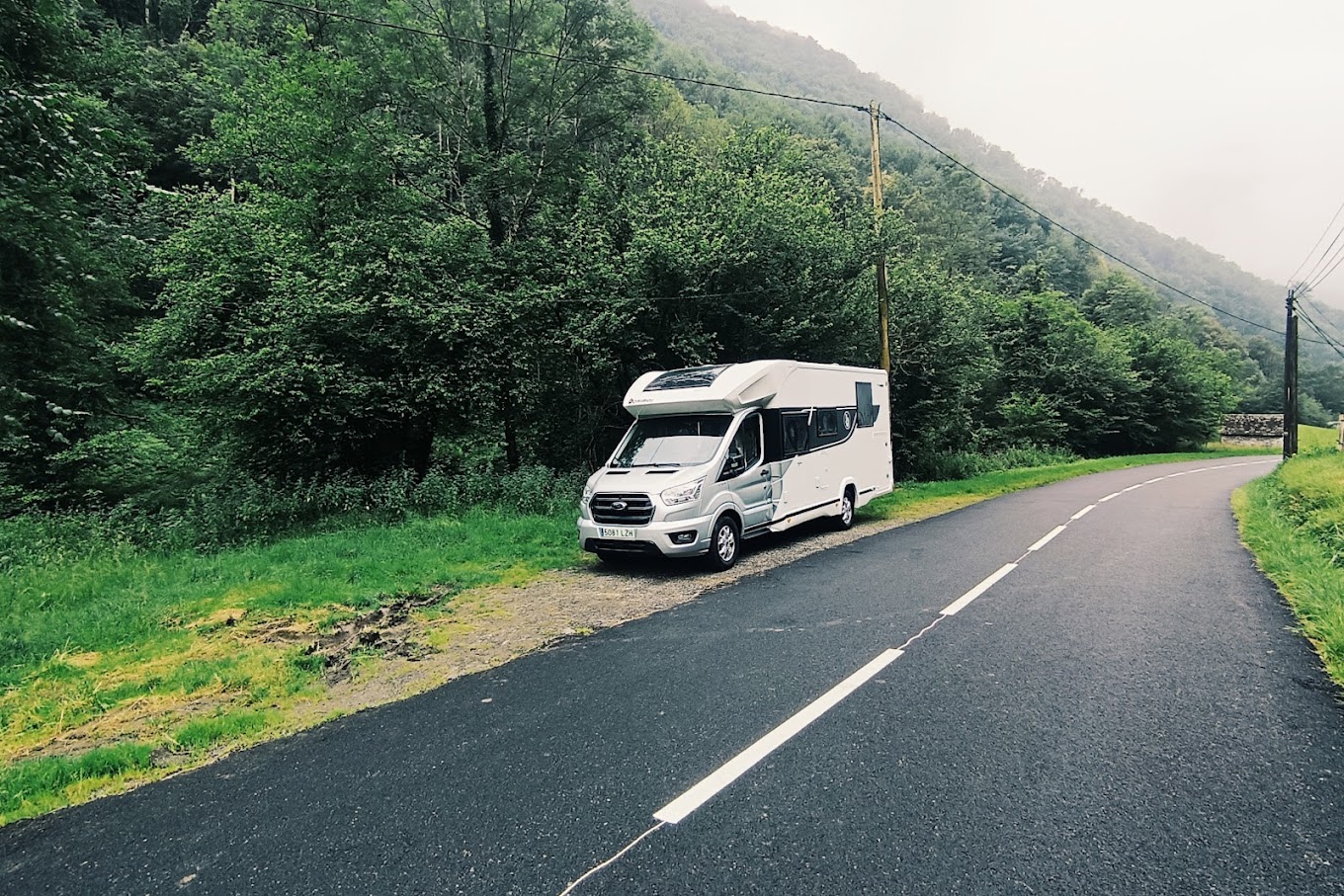 autocaravana aparcada en una carretera con vegetacion