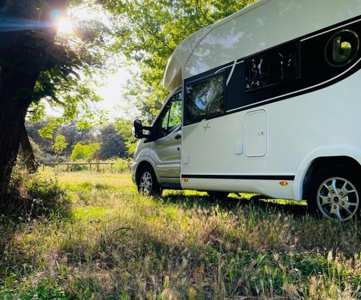 Autocaravana a la sombra de un árbol en el campo